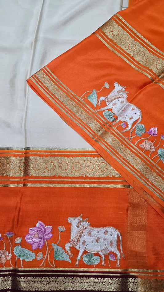 Mysore crepe silk saree in KSIC Finish in cream with orange pichwai embroidery pattern
