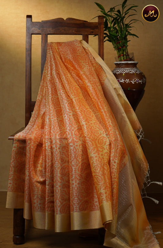 Gold tissue saree in with orange bandini prints and goldzari border