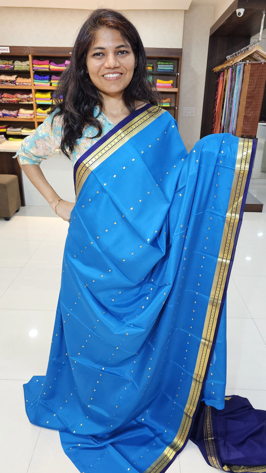 Mysore crepe silk saree with KSIC Finish in peacock blue, with blue in small zari motifs pattern.