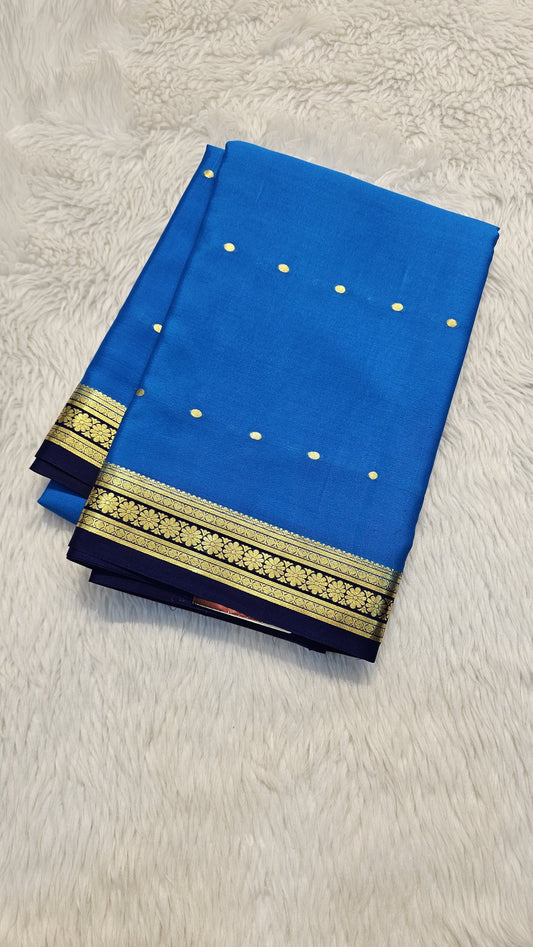 Mysore crepe silk saree with KSIC Finish in peacock blue, with blue in small zari motifs pattern.