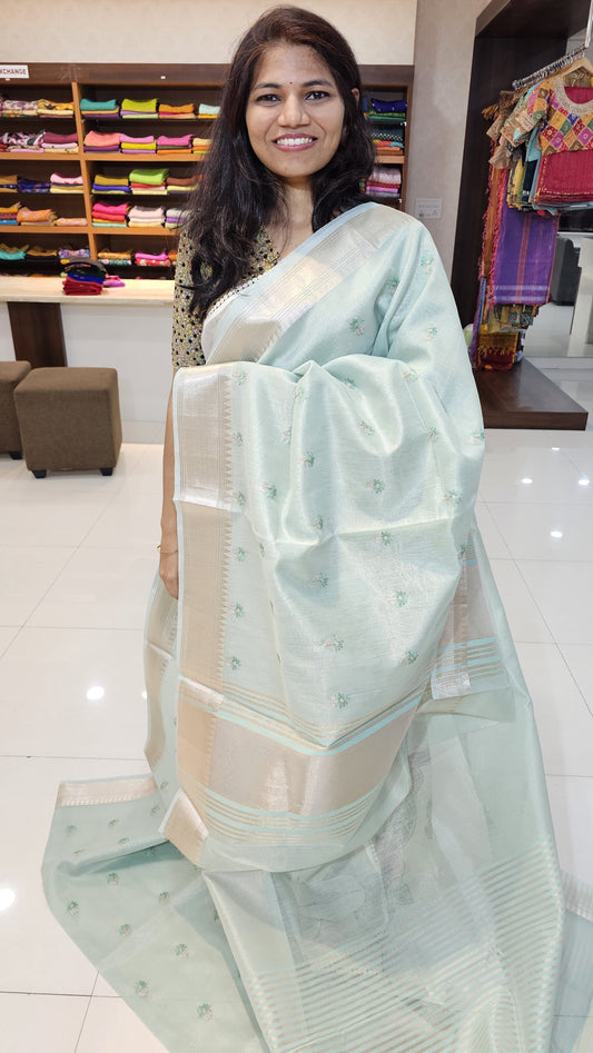 Semi organza fancy saree in light teal self in silver zari border with allover buttas